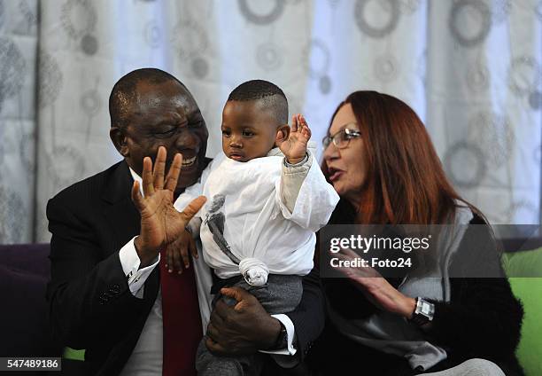 Deputy President Cyril Ramaphosa and HIV Aids activist Gail Johnson play with a one-year-old boy during Ramaphosas visit at Nkosis Haven on July 13,...