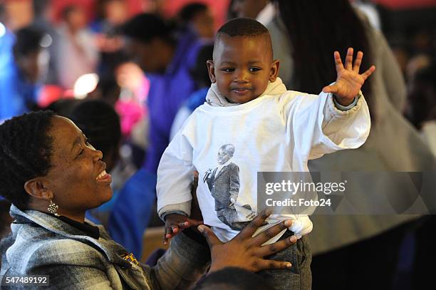 Puleng Makhanya plays with a one-year-old boy during a visit at Nkosis Haven on July 13, 2016 in Johannesburg, South Africa. Deputy President Cyril...