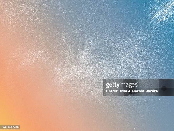cloud of water drops floating in the air on a bottom of colors - fond orange photos et images de collection