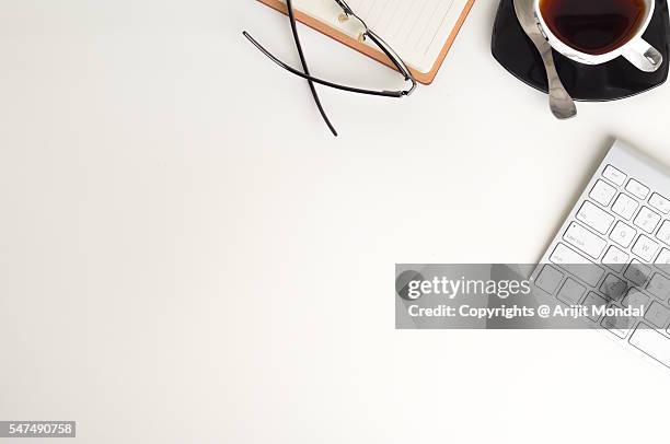 office table top view with black tea with cup, pen, computer keyboard and spectacle - tea cup overhead view photos et images de collection
