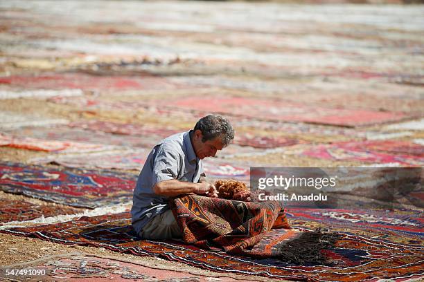 Hand made carpets, brought from varied regions of Turkey, are laid under the sun on a field to soften their color in Dosemealti district of Turkey's...