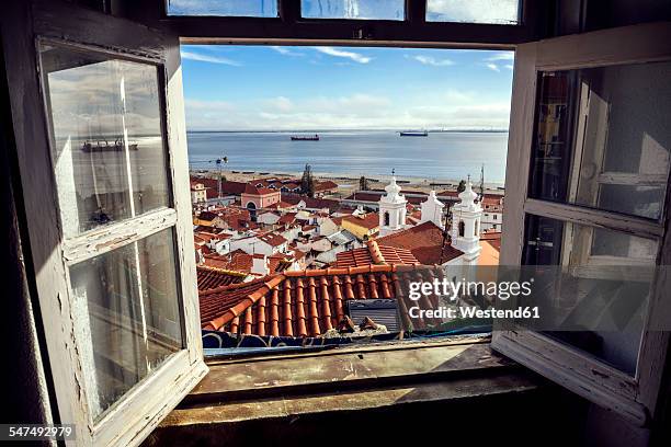 portugal, lisbon, view of alfama neighborhood and river tejo through open window - lissabon stockfoto's en -beelden