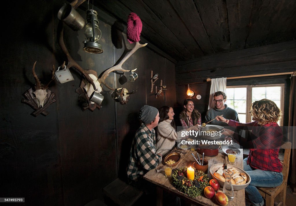Group of young people eating in mountain hut