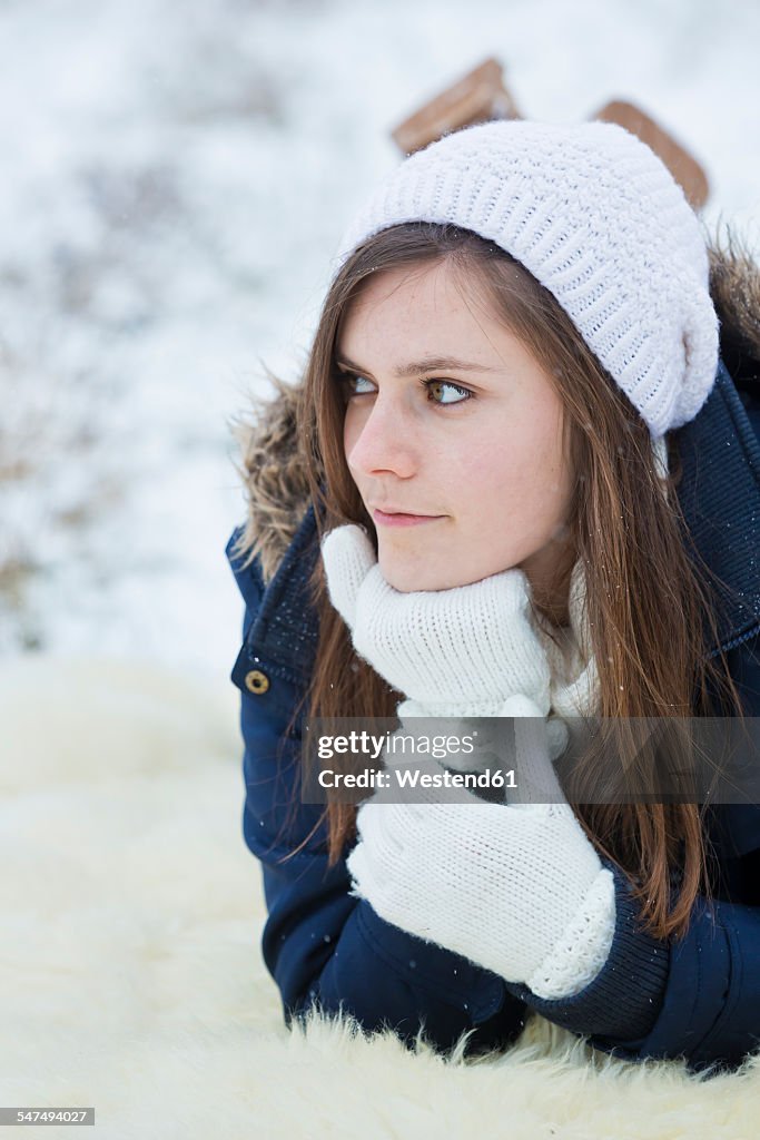 Young woman lying on fur at snow