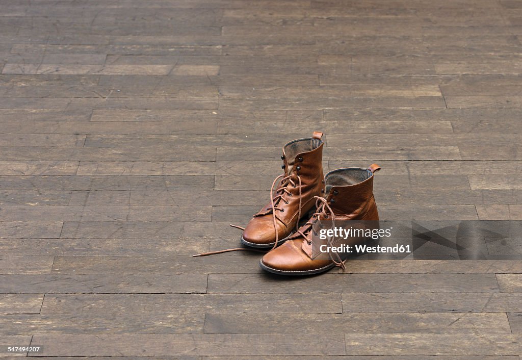 Pair of brown boots on wooden floor