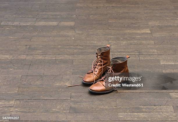 pair of brown boots on wooden floor - leather boots stock pictures, royalty-free photos & images