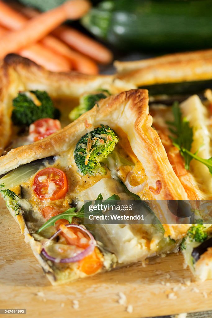 Piece of vegetarian quiche with different vegetables