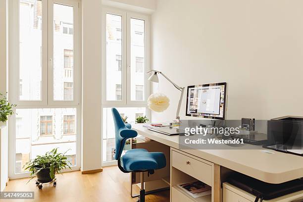 home office with computer desk in modern building - schreibtisch stock-fotos und bilder