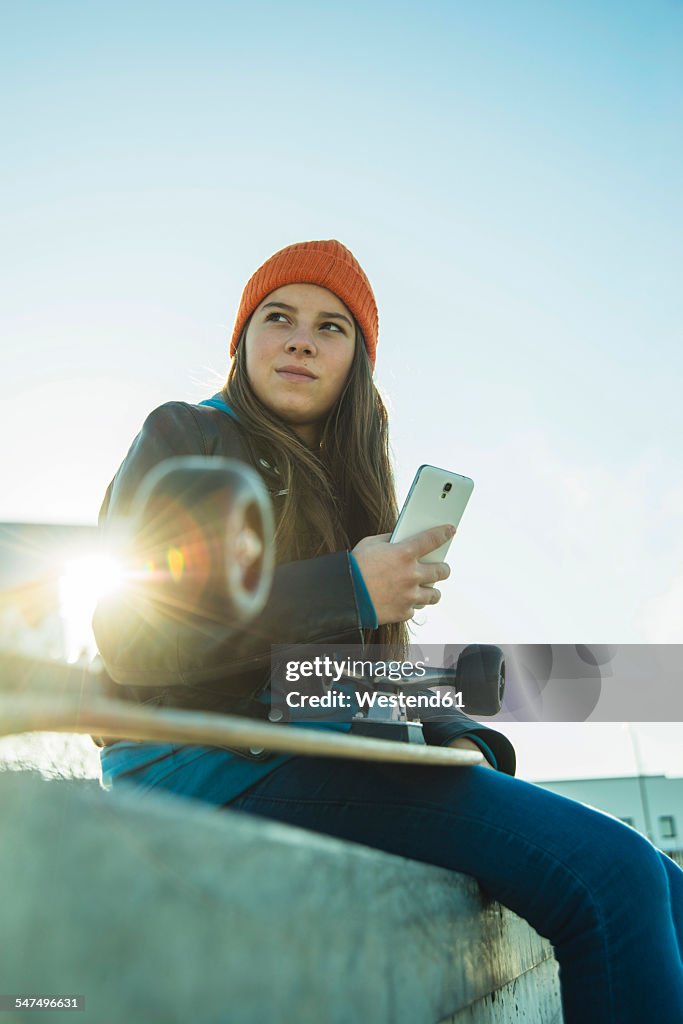 Teenage girl with cell phone in skatepark