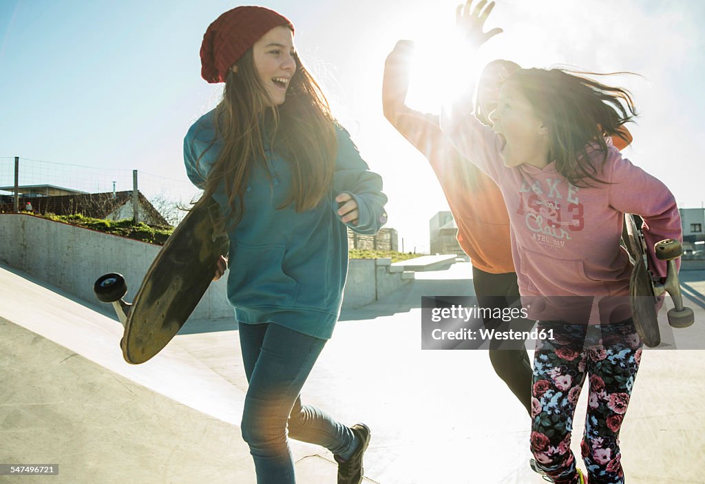 Three girls running in skatepark