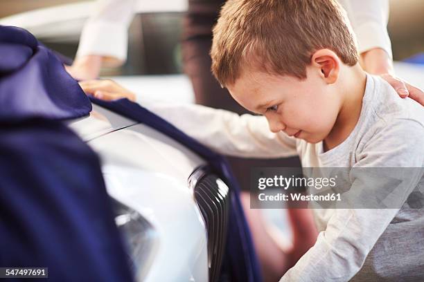 boy at car dealer unveiling tarpaulin - car launch event stock pictures, royalty-free photos & images