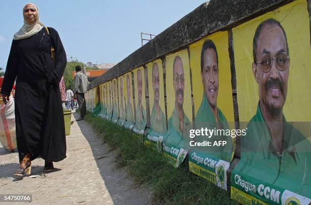 Zanzibar, TANZANIA, UNITED REPUBLIC OF: A Zanzibari woman walks 05 September 2005 along a wall covered with campaign posters of Zanzibar ruling party...