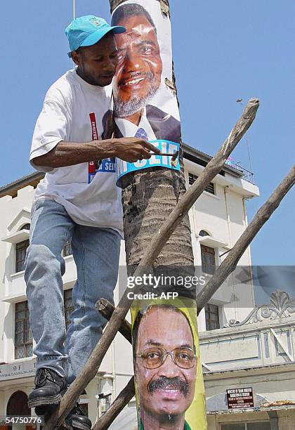 Zanzibar, TANZANIA, UNITED REPUBLIC OF: A Zanzibari glues 05 September 2005 a poster of the main opposition candidate Seif Sheriff Hamad above...