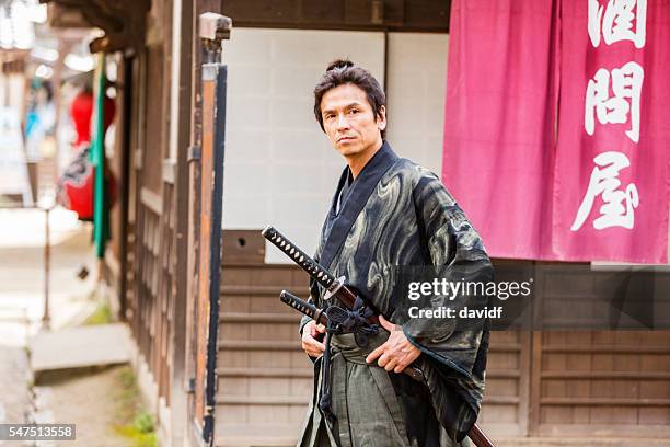 ronin samurai warrior with katana in a traditional japanese village - katana stock pictures, royalty-free photos & images