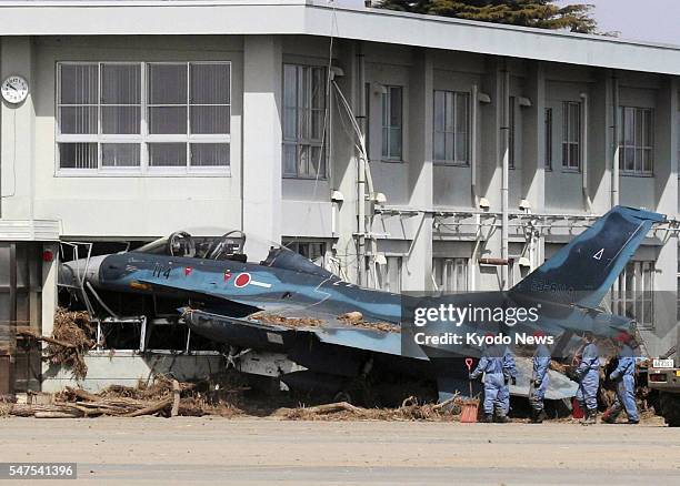 Higashimatsushima, Japan - Photo taken on March 14 shows an F-2 jet fighter of the Japan Air Self-Defense Force which was swept into a building by a...