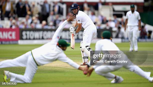 England captain Alastair Cook plays the ball between Azhar Ali and Younis Khan of Pakistan during day two of the 1st Investec Test between England...