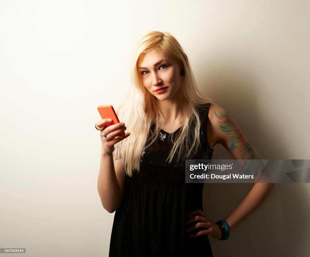 Portrait of tattooed woman with mobile phone.