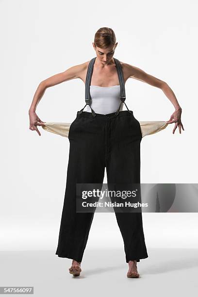 woman with empty pockets - women in suspenders stock-fotos und bilder