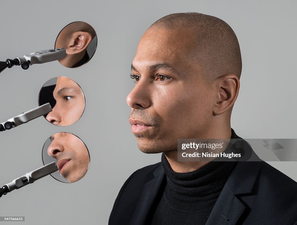 Portrait of man with 3 round mirrors