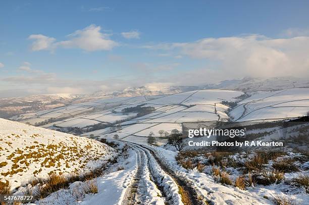 snowy hillside track in a winter landscape - snow landscape stock pictures, royalty-free photos & images