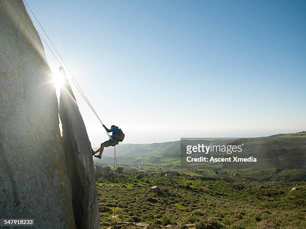 climber rappels (abseils) from ridge crest - 爬山繩 個照片及圖片檔