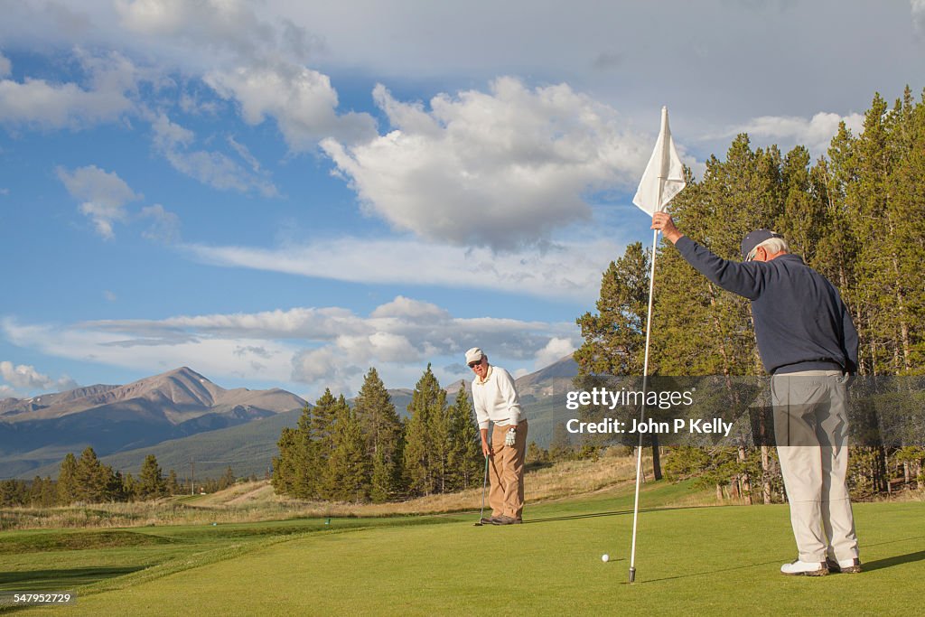 Two senior men on a golf green
