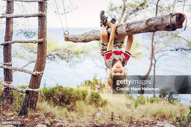 boy hanging upside down on tree trunk - repgunga bildbanksfoton och bilder
