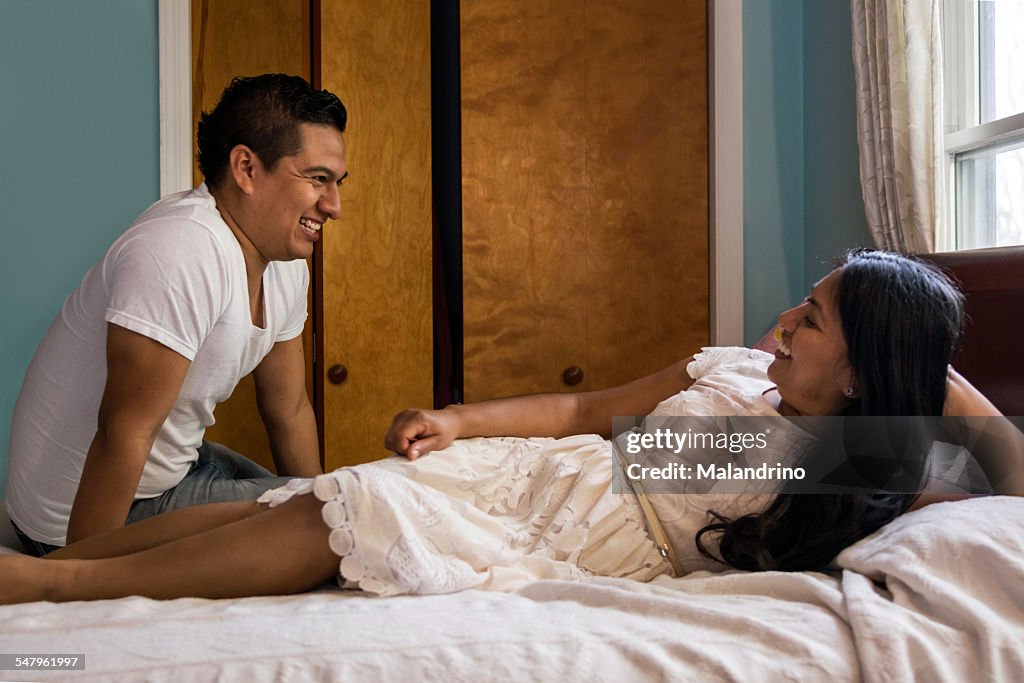 Couple laughing on a bed