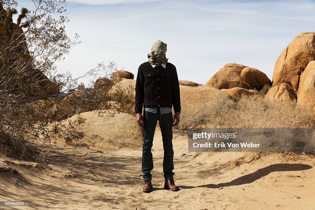 Man with scarf wrapped around face in desert