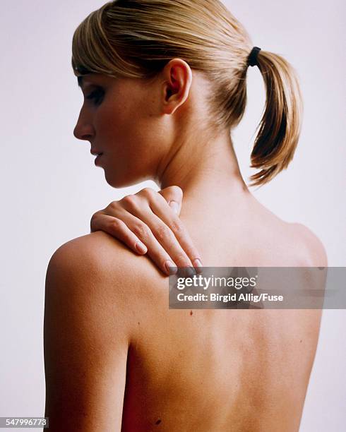 blond naked woman touching shoulder - woman torso stock pictures, royalty-free photos & images