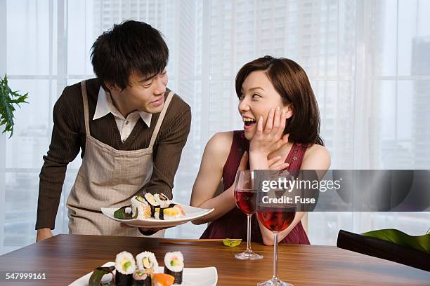 man serving woman sushi - wellness kindness love stock pictures, royalty-free photos & images