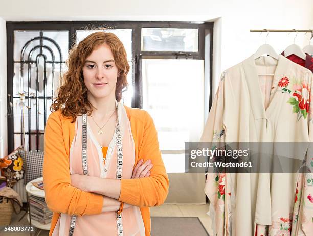 portrait of smiling female fashion designer with tape measure at her studio - woman measuring tape stock pictures, royalty-free photos & images