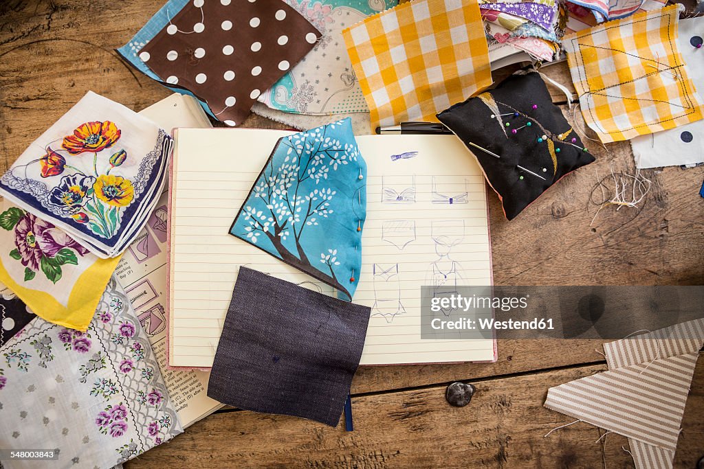 Sketchbook and cloth samples on work desk
