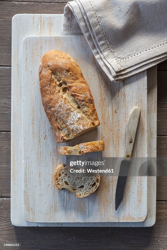 Baguette and knife on kitchen board