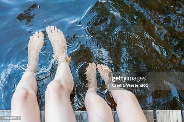 finland, lake saimaa, children splashing feet in water - feet girl stock pictures, royalty-free photos & images