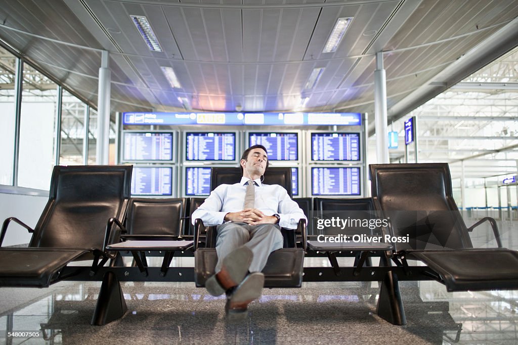 Businessman napping in airport terminal