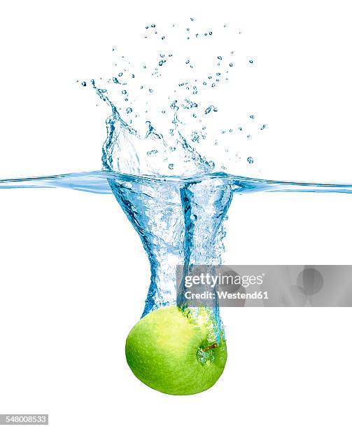 green apple falling into water - apple water splashing stock pictures, royalty-free photos & images