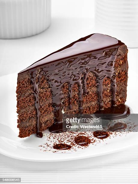piece of cream chocolate cake on white plate - chocoladeglazuur stockfoto's en -beelden