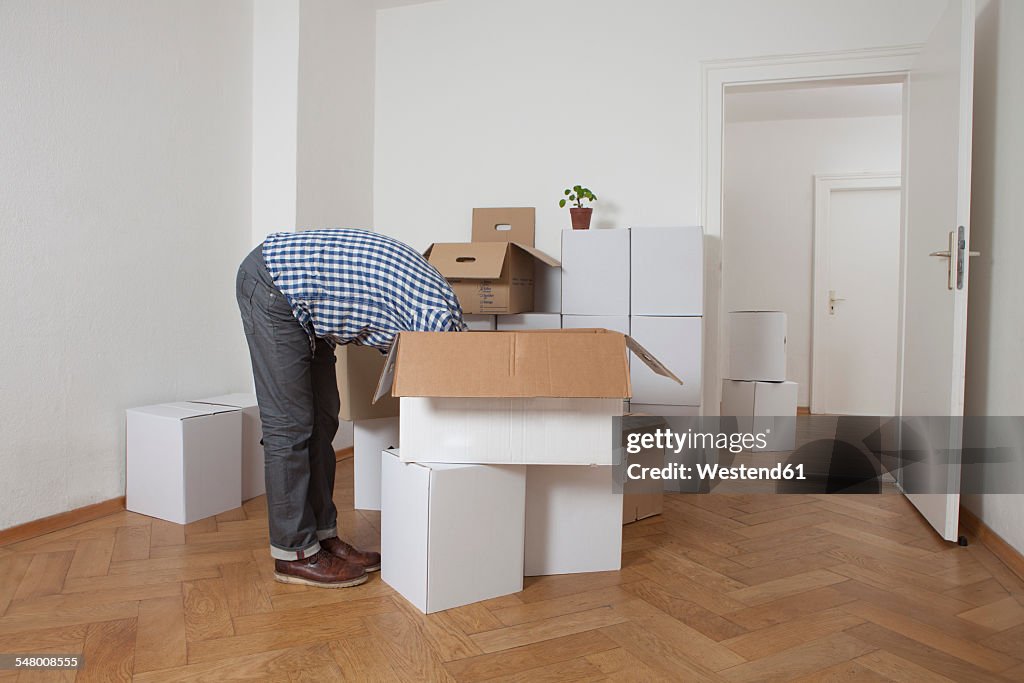Man searching head first in cardboard box
