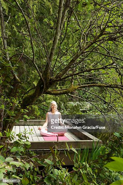 woman meditating - halber lotussitz stock-fotos und bilder