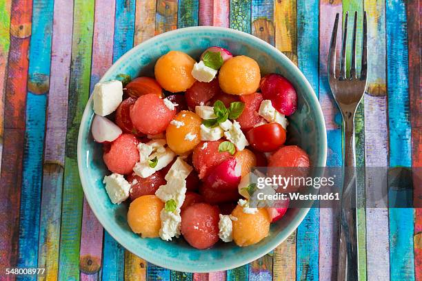 melon salad with feta, tomato and red radish in bowl - feta stock pictures, royalty-free photos & images