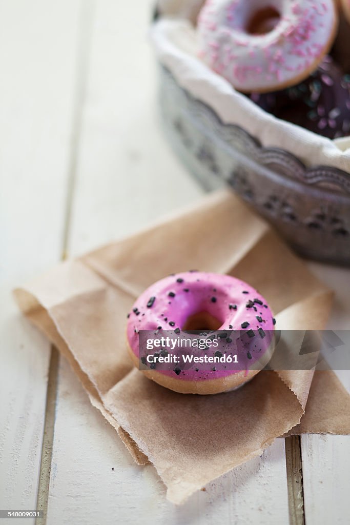 Pink, chocolate and white donuts with sprinkles, studio