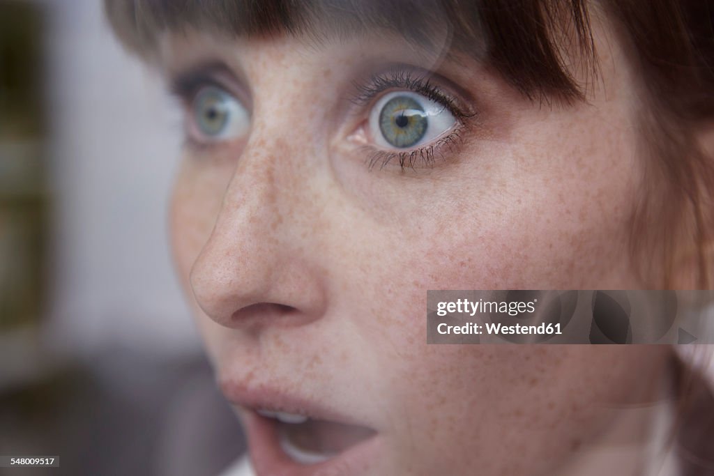 Frightened woman behind window