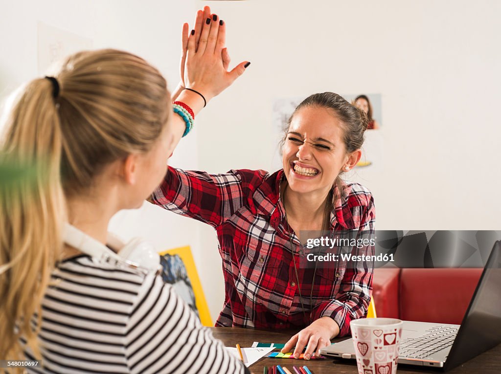 Two happy female friends at home