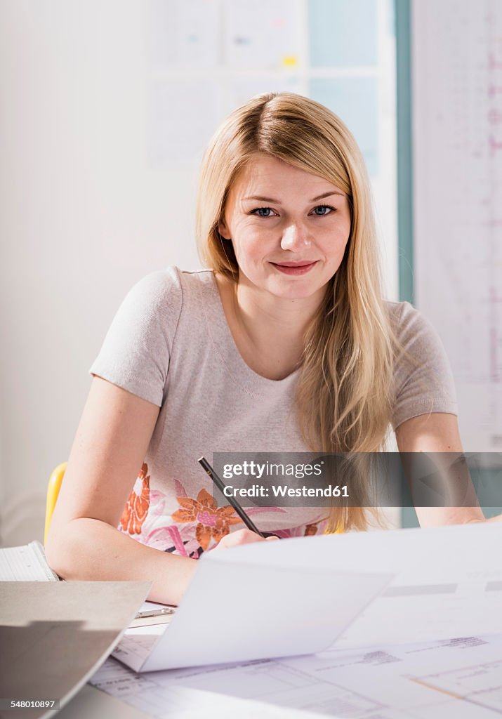 Portait of blond young woman at desk