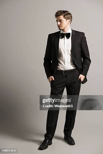 young man with hands in his pockets wearing black suit, white shirt and bow - smoking imagens e fotografias de stock
