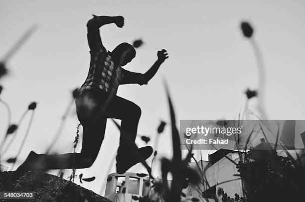 young man jumping - man running scared stock pictures, royalty-free photos & images