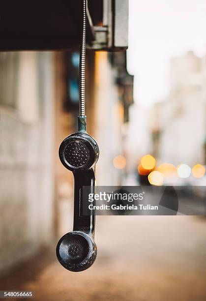 phone handset hanging by the chord on the street - telefono stock pictures, royalty-free photos & images
