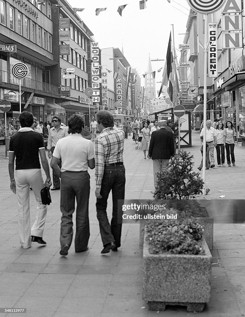People on shopping expedition, three young men, aged 25 to 30 years, shopping street, pedestrian zone, Bahnhof Street, in the background the Evangelic City Church, D-Gelsenkirchen, Ruhr area, North Rhine-Westphalia - 31.08.1979