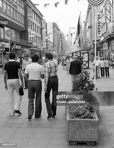 People on shopping expedition, three young men, aged 25 to 30 years, shopping street, pedestrian zone, Bahnhof Street, in the background the...